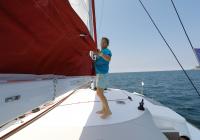 girl raising mainsail sailing yacht
